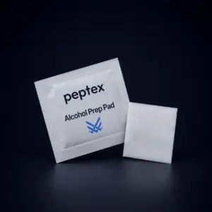 Peptex alcohol prep pad sachet with sterile cleaning wipe displayed on a premium dark studio background.